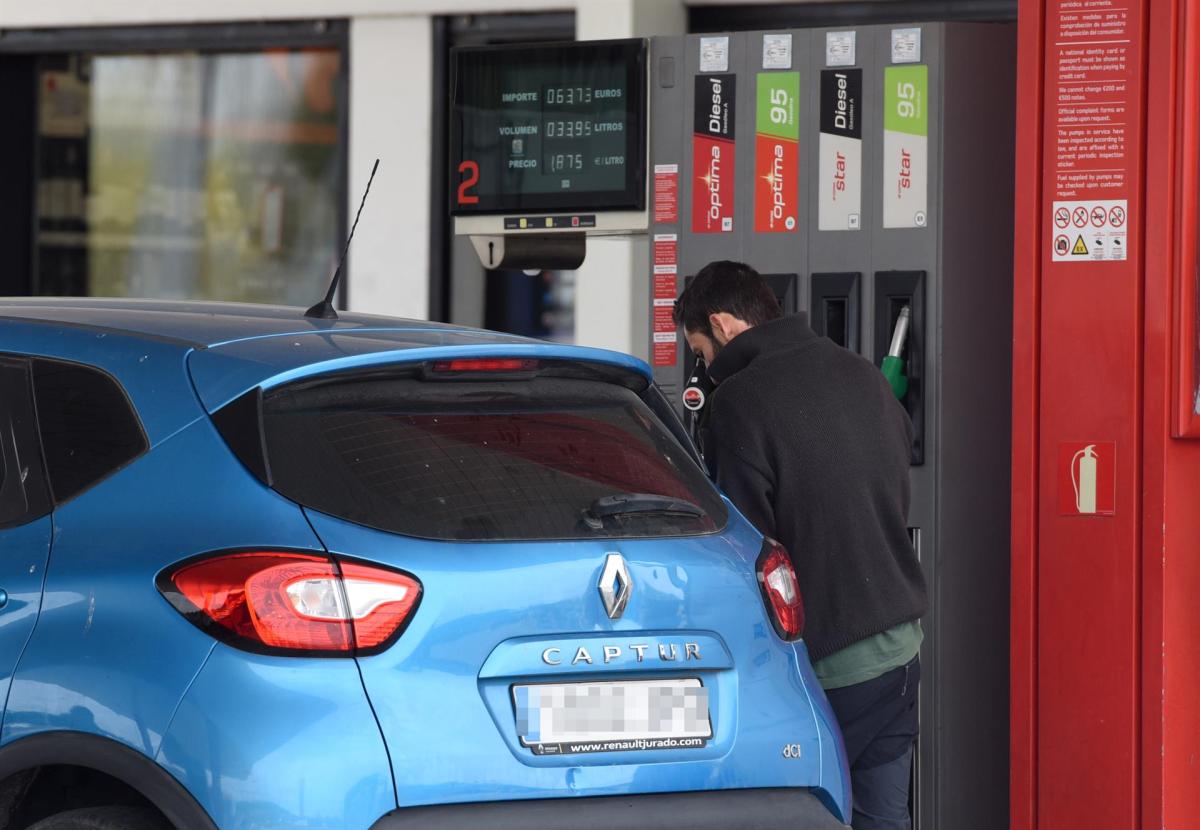 Un hombre echa gasolina a su vehículo en una estación de servicio.