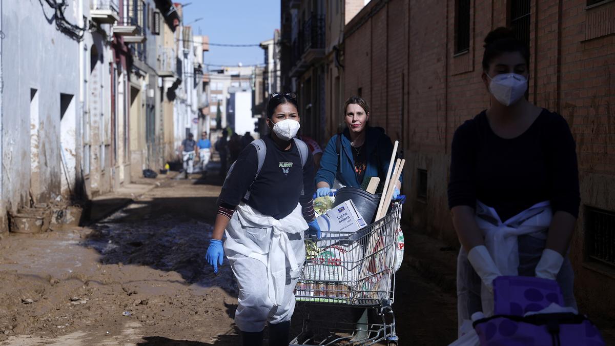 Decenas de voluntarios siguen extrayendo lodo de las calles, este domingo, en la población de l`horta Sud de Catarroja. 