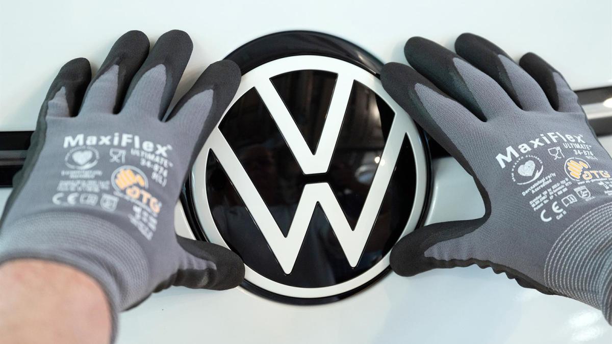  Un empleado de Volkswagen coloca el logotipo de VW en un VW ID.3 durante una visita de prensa a la Fábrica Transparente de Volkswagen.