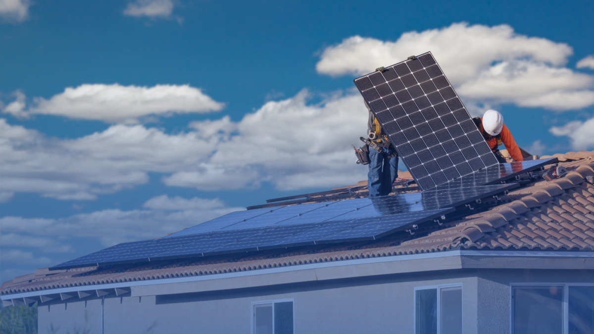 Trabajadores de Unieléctrica instalan una placa solar de autoconsumo.