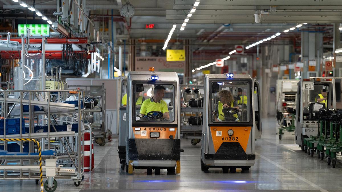 Empleados conducen carretillas elevadoras en la fábrica de Seat en Martorell.