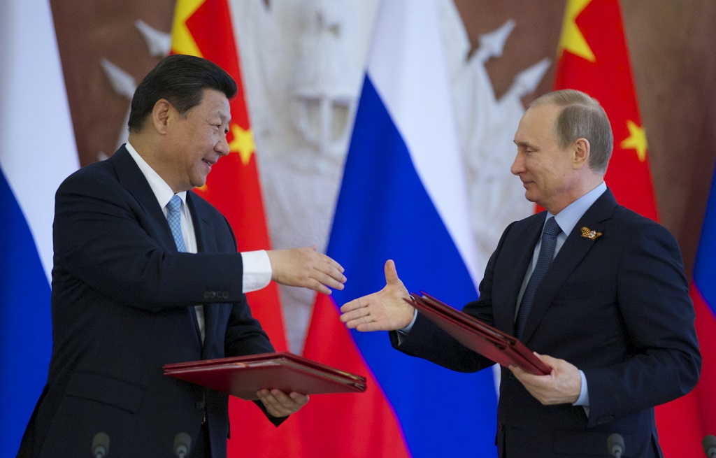 Russian President Vladimir Putin, right, and Chinese President Xi Jinping exchange documents at the signing ceremony in the Kremlin in Moscow, Friday, May 8, 2015. Russian and Chinese leaders have signed a plethora of deals in Moscow, giving Russia billions in infrastructure loans. (AP Photo/Alexander Zemlianichenko)