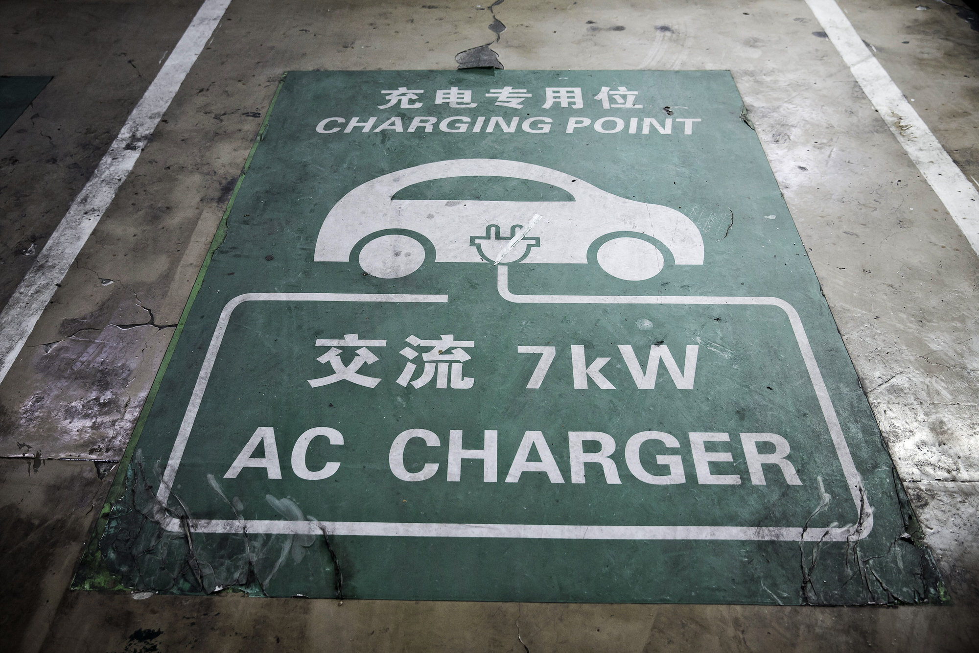 Signage for a parking space for an electric automobile is displayed at a charging station operated by Tellus Power Inc. at an underground parking lot in Beijing, China, on Wednesday, March 9, 2016. While air pollution in the nation's capital has improved slightly, residents still frequently don face masks to filter the smog, including during a string of days recently air quality was listed as hazardous. Photographer: Qilai Shen/Bloomberg