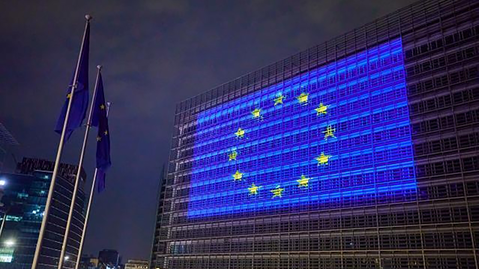 Vista del Berlaymont de noche con el emblema europeo.