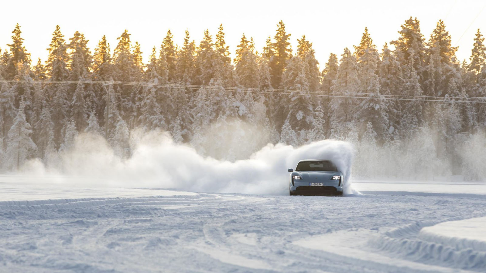 Hay que conocer las reacciones del coche en condiciones extremas.  - Porsche /></p><p>La conducción agresiva es el peor enemigo en invierno. Acelera progresivamente, anticipa frenadas y mantén velocidades constantes por debajo de 110 km/h en autovía. <strong>Activa el modo Eco, que limita la respuesta del acelerador</strong> y reduce el consumo de accesorios como la calefacción. ​</p>
<p><strong>En carreteras con hielo o nieve, aumenta la distancia de seguridad</strong> y reduce la velocidad: no solo por seguridad, sino porque a menor velocidad, menos aerodinámica drag y menos gasto. <strong>Estudios muestran que bajar de 120 a 100 km/h puede ahorrar un 20% en consumo invernal</strong>. Piensa en tu coche como en una bicicleta: cuanto más suave pedaleas, más lejos llegas. ​ <strong>No bajes de un 20% de batería nunca</strong>, especialmente si aparcas fuera. El coche consume energía en standby para mantener sistemas activos, y el frío acelera esa pérdida (hasta 1 km/hora parado). ​</p>
<h3>Caliéntate pero sin derrochar</h3>
<p><img src=