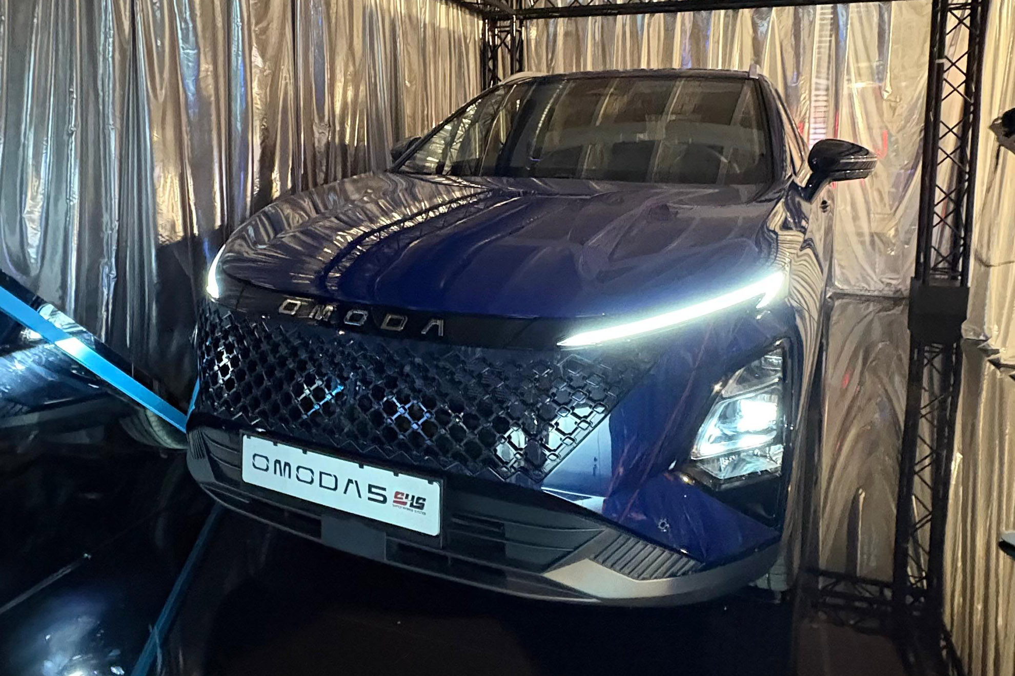 El frontal es lo que más cambia.  - Diego Ávila /></p><p>De manera paralela, durante la presentación, pudimos igualmente comprobar cómo el Omoda 5 sufría su tercera actualización en poco menos de dos años. Externamente será reconocible por la <strong>nueva parrilla integrada y luces diurnas más estilizadas</strong>, mientras que en el interior se ha revisado el sistema multimedia con doble pantalla de 12,3 pulgadas integrando ahora el chip 8155 que proporciona un manejo más fluido y un arranque más rápido.</p>
<p>Sin embargo, el protagonista de esta renovación no es otro que la mecánica, pues ahora el Omoda 5 pasará a lucir la <strong>etiqueta ECO de la DGT</strong> gracias al nuevo sistema híbrido autorrecargable denominado igualmente SHS. Una semejanza de siglas que puede llevar a la confusión comercial y aunque desde la marca en España aseguran que están intentando cambiarlo, de momento seguirá así.</p>
<p><img src=