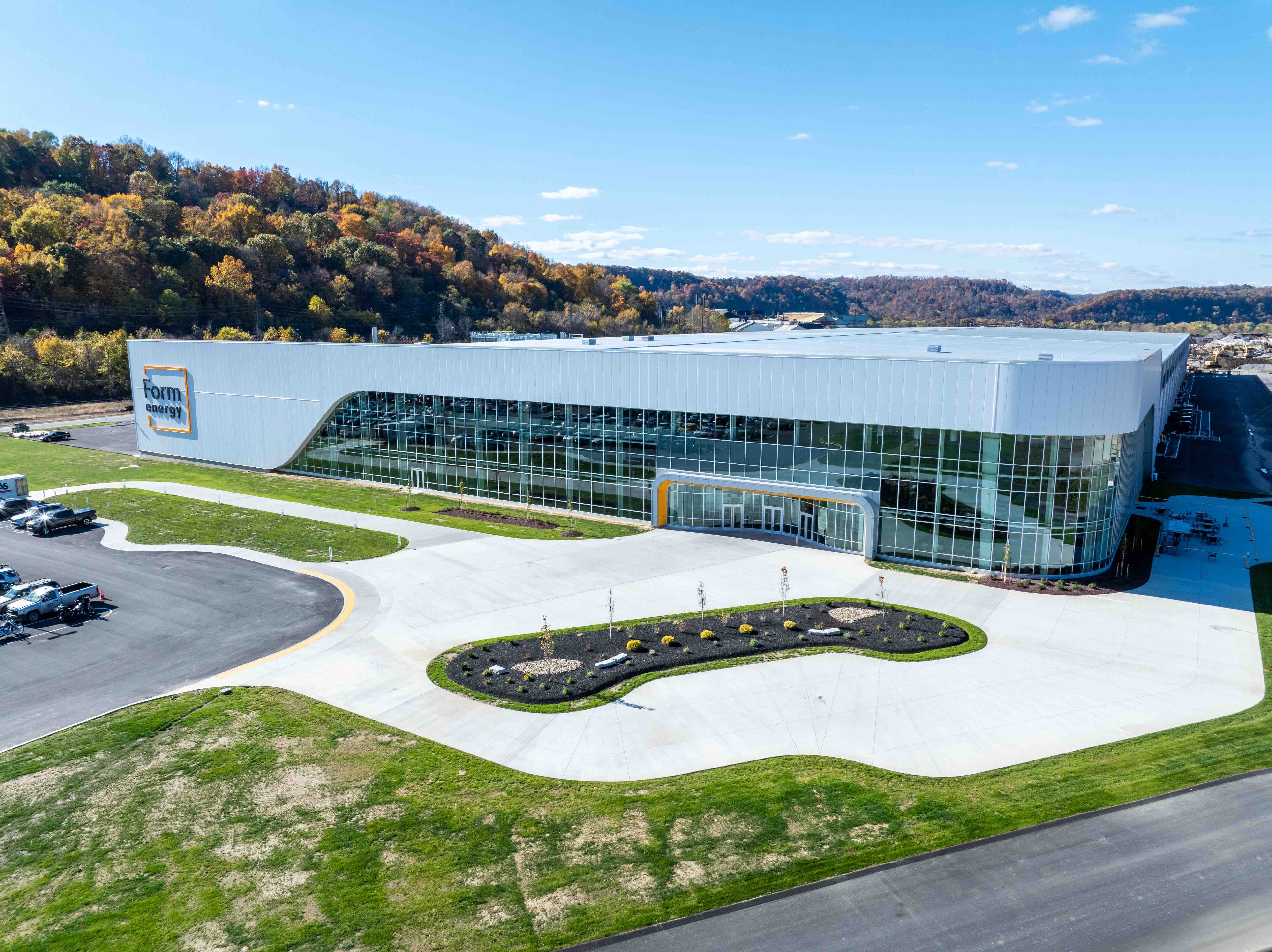 Sede la empresa Form Energy en Estados Unidos. - Imagen: Form Energy /></p><h3>Hierro, aire y una nueva ecuación para la energía</h3>
<p>La tecnología <em>iron-air</em> es un tipo de <strong>almacenamiento electroquímico</strong> basado en un principio simple: <strong>oxidar y reducir el hierro</strong> para almacenar y liberar electricidad. Durante la descarga, el hierro reacciona con el oxígeno del aire y se oxida, es decir, se convierte en óxido de hierro, liberando energía. Durante la carga, el proceso se invierte: el óxido de hierro se reduce de nuevo a hierro metálico, almacenando electricidad. El resultado es un sistema capaz de mantener energía disponible durante <strong>varios días</strong>, no solo horas. Entre sus ventajas destacan el <strong>bajo coste</strong> y la <strong>abundancia del hierro</strong>, que podrían reducir drásticamente los costes frente a las baterías de litio. Sin embargo, su <strong>eficiencia es menor</strong> y los sistemas deben superar aún desafíos relacionados con la potencia y la durabilidad.</p>
<p>A diferencia de las baterías de ion-litio, que solo pueden proporcionar energía durante unas pocas horas debido a su alto coste relativo, las baterías de hierro-aire pueden suministrar energía durante varios días. Jaramillo indica que estas “están hechas de algunos de los materiales más seguros, baratos y abundantes del planeta —hierro de bajo coste, agua y aire— y proporcionan una solución sostenible y segura para satisfacer la creciente demanda de seguridad y resiliencia de la red”.</p>
<p>“Nuestro objetivo es que la eficiencia media de ida y vuelta de nuestra batería de hierro-aire esté entre el 40 % y el 50 % a nivel de sistema cuando alcancemos la escala completa en la próxima década. Definimos la eficiencia media de ida y vuelta como la que incluye la autodescarga, las cargas auxiliares necesarias para el funcionamiento de la batería y la eficiencia de la propia química”.</p>
<p>Defiende, además, un modelo <strong>complementario</strong>, donde distintas tecnologías conviven según la necesidad: “Creemos que <strong>un sistema rentable necesita tanto activos de almacenamiento a corto plazo</strong> (ion-litio) <strong>como de largo plazo y varios días</strong> (hierro-aire): los sistemas de alto coste y alta eficiencia para las necesidades intradía (ion-litio) y un sistema de coste mucho menor que cubra varios días con un equilibrio apropiado entre coste y eficiencia (hierro-aire) para lograrlo”. En términos de durabilidad, añade que “nuestra batería puede ciclar unas 13 veces al año a 100 horas, lo cual es más que suficiente para proporcionar fiabilidad durante periodos prolongados de estrés crítico en la red”.</p>
<p>La hoja de ruta industrial de Form Energy prevé un <strong>aumento progresivo de su capacidad productiva</strong>. Jaramillo explica que “tras los proyectos de 2025, avanzaremos hacia instalaciones comerciales a medida que aumente la producción y disminuyan los costes. A finales de esta década, Form Energy pretende ejecutar proyectos de almacenamiento de varios días más grandes y sentar las bases para un despliegue internacional. Para la década de 2030, esperamos alcanzar una capacidad de fabricación y entrega a escala de gigavatios, contribuyendo a una mayor fiabilidad y resiliencia de la red en todo el mundo”.</p>
<p><img src=