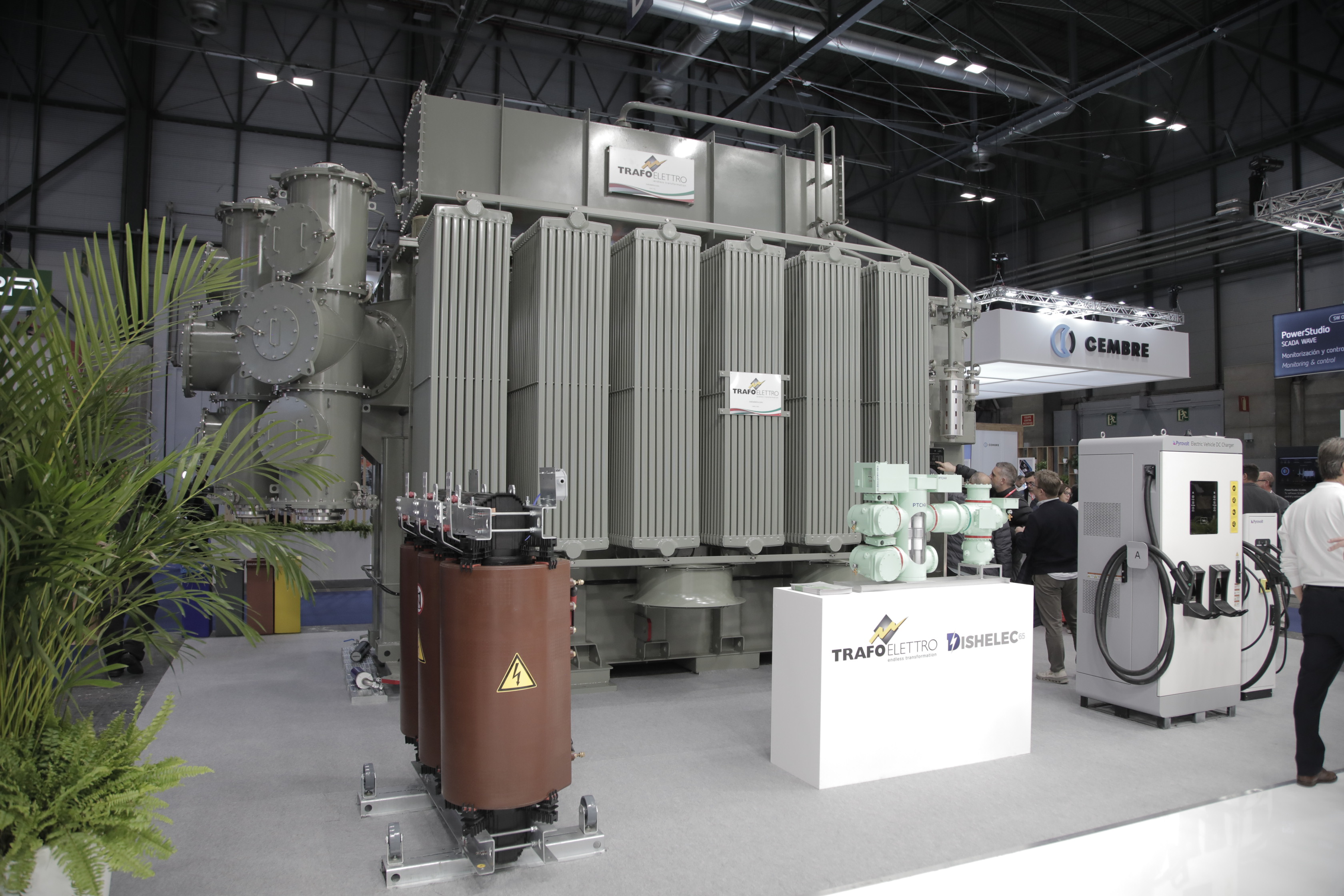 /></p><p>Aprovechamos la feria Matelec de hace unos días para conocerlas. Se trata de <strong>Dishelec65</strong> y su socio italiano <strong>Trafo Elettro</strong>. Estas compañías trabajan para los principales actores del sector eléctrico español, que son los encargados de llevar la energía hasta las subestaciones y, desde allí, transportar la electricidad para distribuirla por todo el país.</p>
<p>En su stand compartido en Matelec, las compañías expusieron un transformador de potencia de 50 MVA 132/30kV que acaparó todas las miradas. Con casi cinco metros de altura, su transporte e instalación supusieron todo un reto. Nunca antes se había visto en la feria un transformador de esta envergadura. También destacamos los equipos libres de SF6 de alta tensión presentados en la feria de la marca Ping Zhi; GIS (Gas Insulated Switchgear) libres de SF6 de 72,5 y 145kV.</p>
<p><img src=